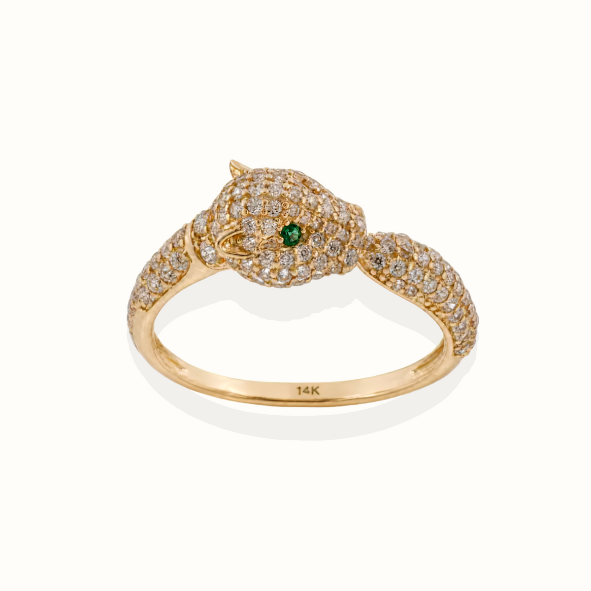 A 14K yellow gold snake ring with pavé-set diamonds and a single green emerald accent in its eye, shown on a clean white background.